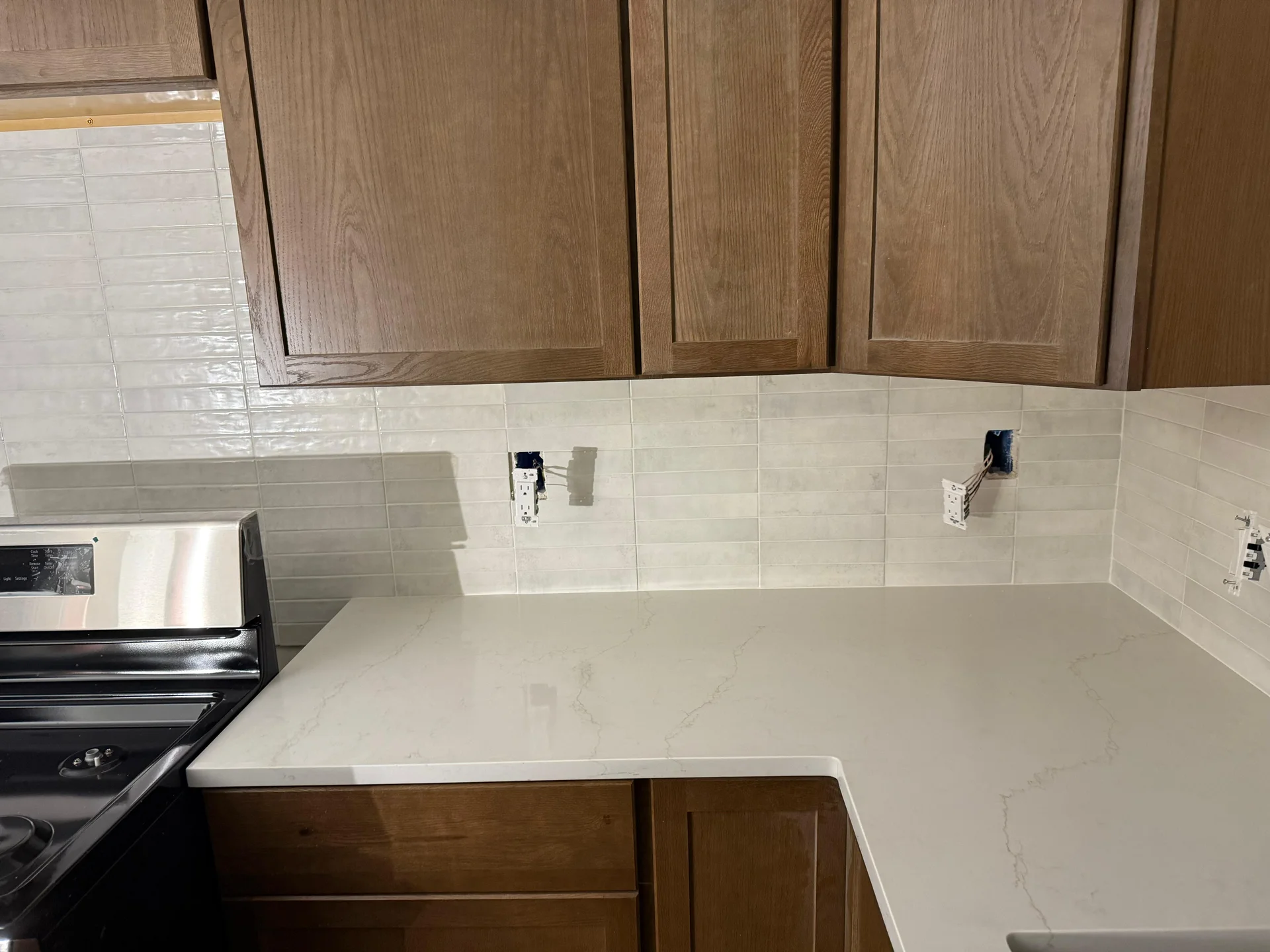 Kitchen backsplash tile installation with white subway tiles and marble countertops by SF Construction in Framingham, MA