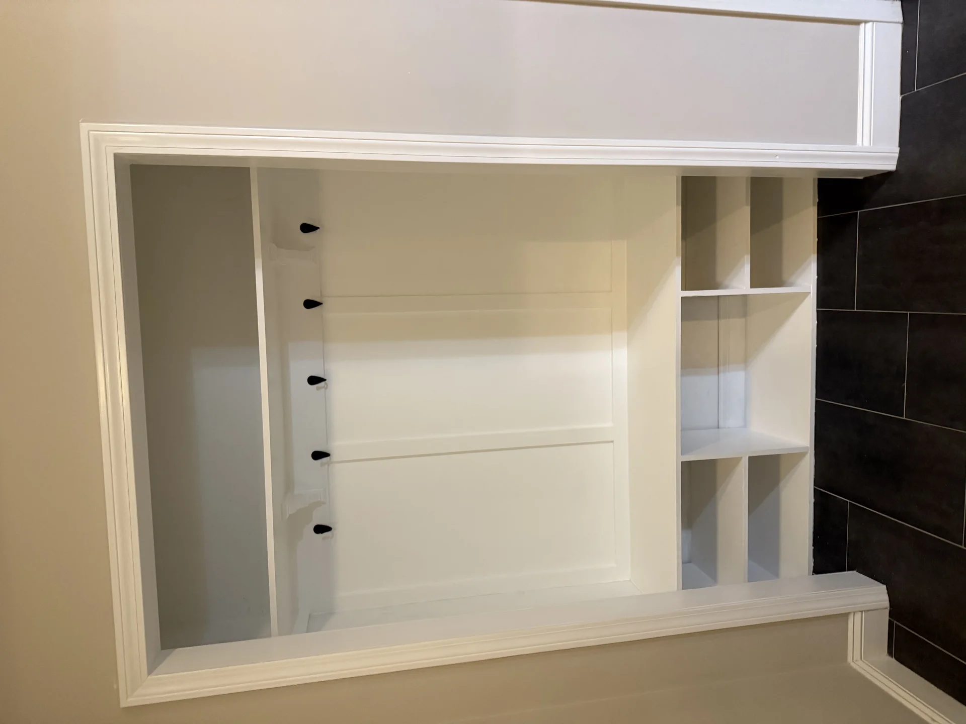 White built-in bathroom cabinet with shelving and mirror installation by SF Construction in Sudbury, MA