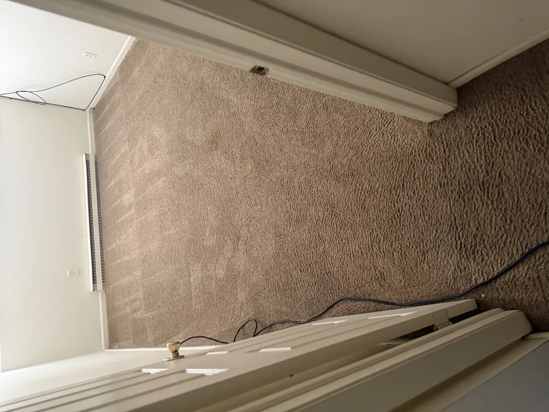 Beige carpet installation with white baseboard and trim work in progress by SF Construction in Marlborough, MA