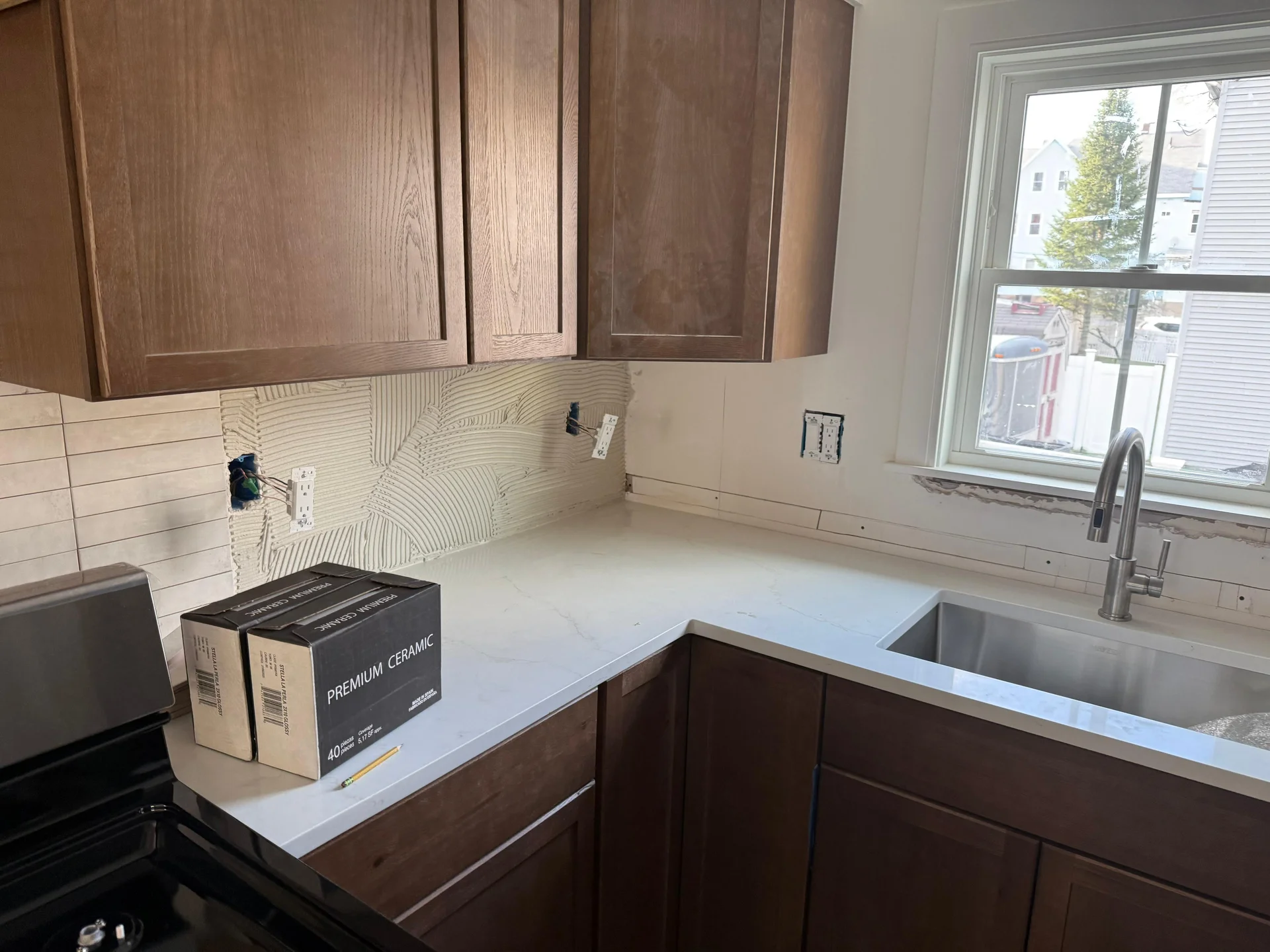 Kitchen remodel with white quartz countertops, dark wood cabinets, textured backsplash tile by SF Construction in Northboroug