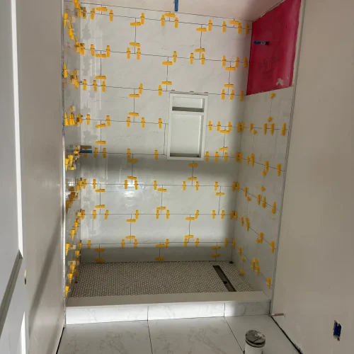 Bathroom shower installation with tile layout and yellow spacers applied by SF Construction in Framingham, MA