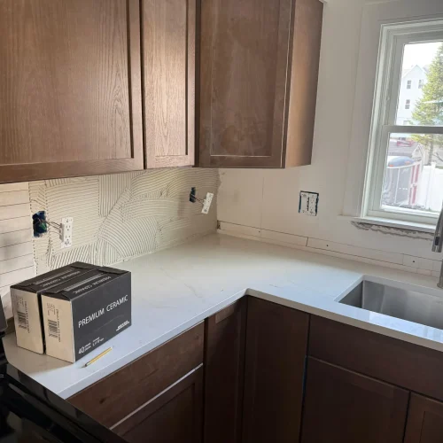 Kitchen remodel with white quartz countertops, dark wood cabinets, textured backsplash tile by SF Construction in Northboroug