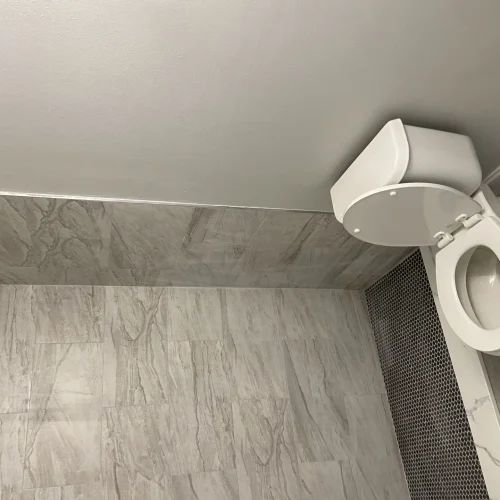 Gray marble-look porcelain tile floor in a remodeled bathroom by SF Construction in MetroWest, MA